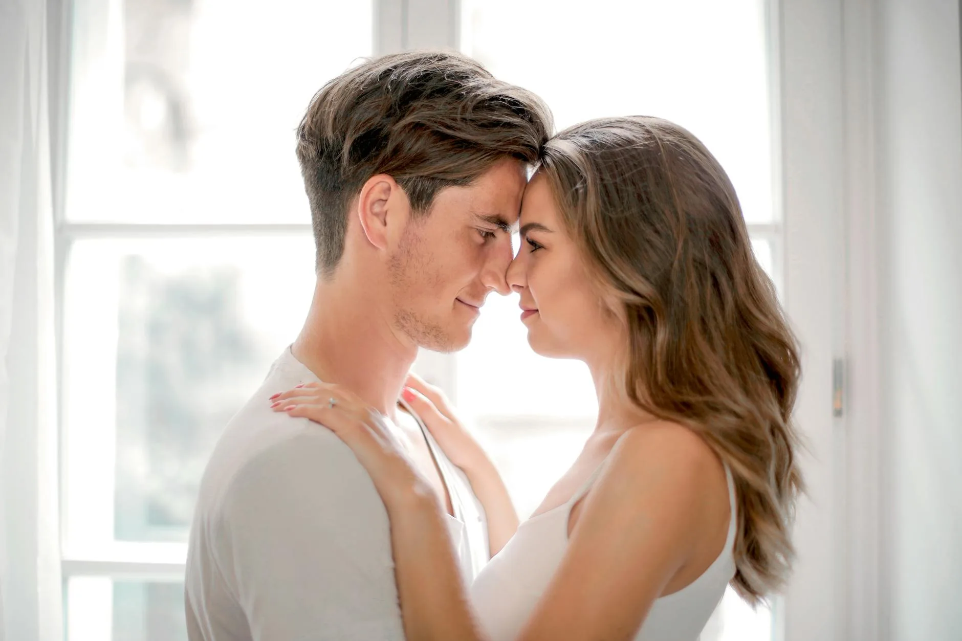 Couple sharing a tender moment by a sunlit window — the lasting relationships Miami matchmakers help their clients build